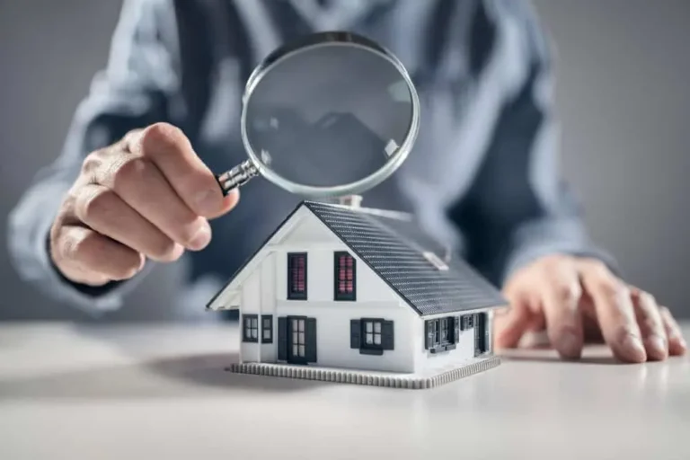 A man inspecting a house with a magnifying glass