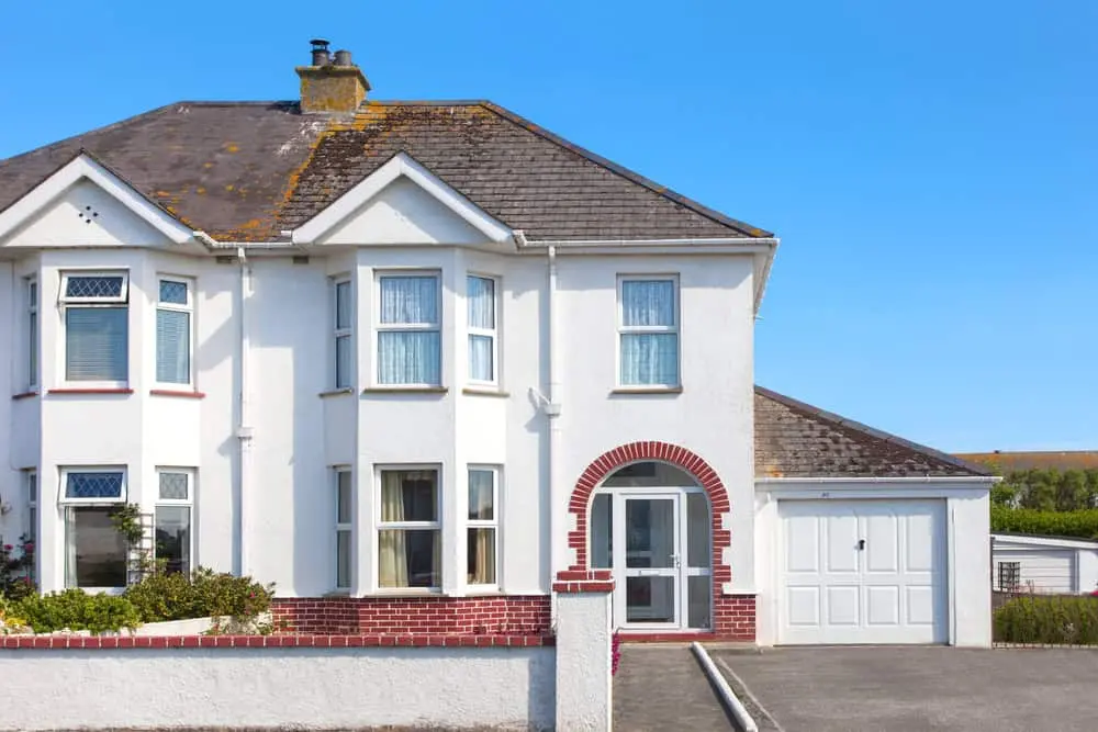 Empty 1930s semi-detached house with drawn curtains — the kind of UK property covered by unoccupied home insurance