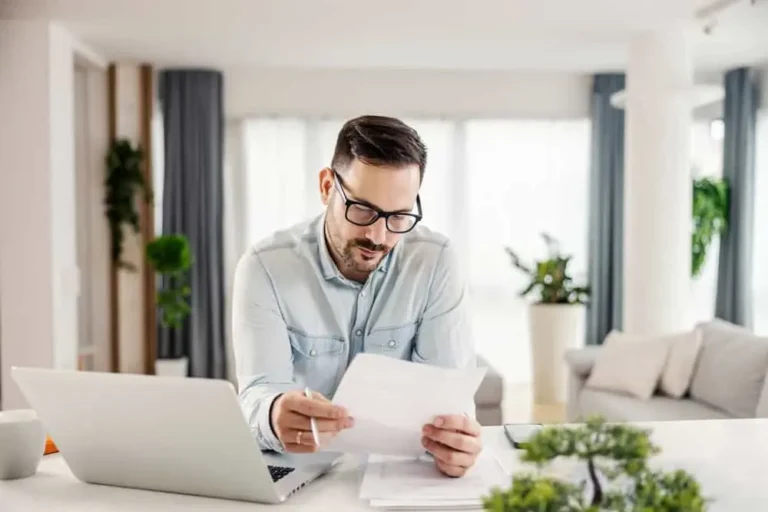 Executor reviewing estate paperwork and researching executor insurance at home